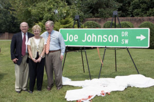 Joe and Pat Johnson with Knoxville Mayor Victor Ashe and a large green Joe Johnson Drive street sign